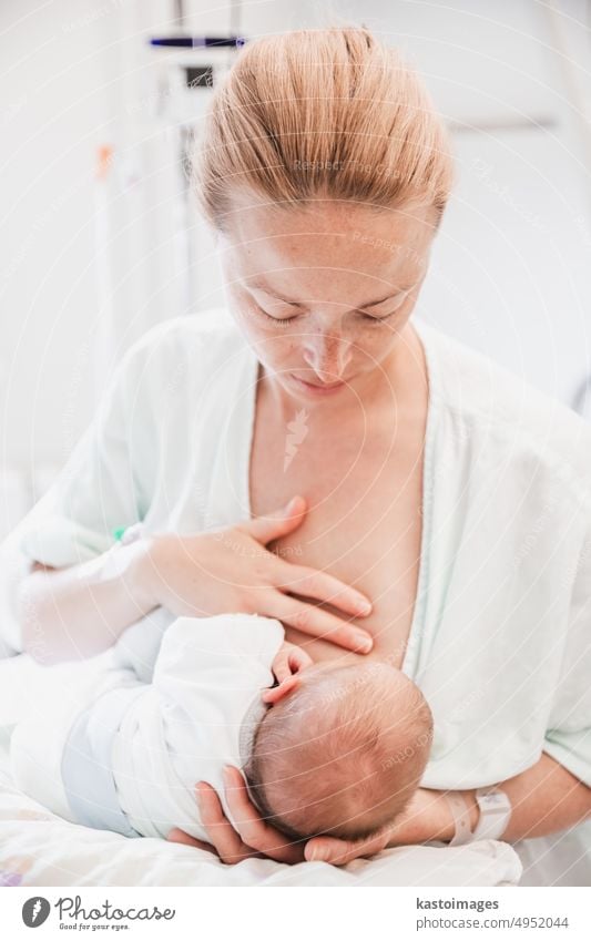 New mother carefully breastfeeds her newborn baby boy in hospital a day after labour birth infant healthy young life pregnancy person motherhood mom giving two