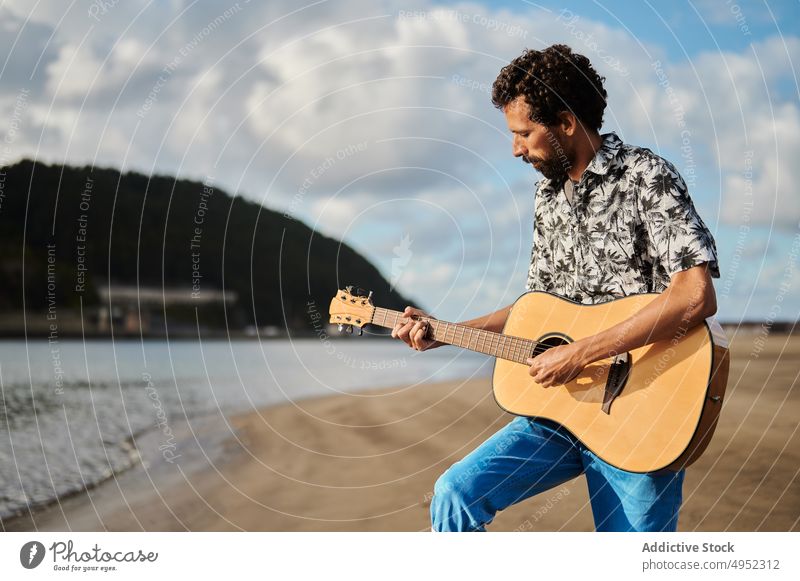 Man playing guitar on beach man summer guitarist music musician song seashore male acoustic hobby sunny melody sound perform talent guy instrument string