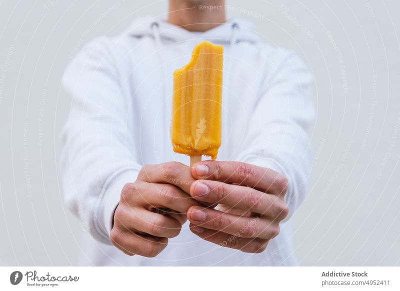 Anonymous man with natural ice lolly looking at camera ice cream cold frozen treat sweet male refresh tasty dessert eco organic yummy guy food delicious