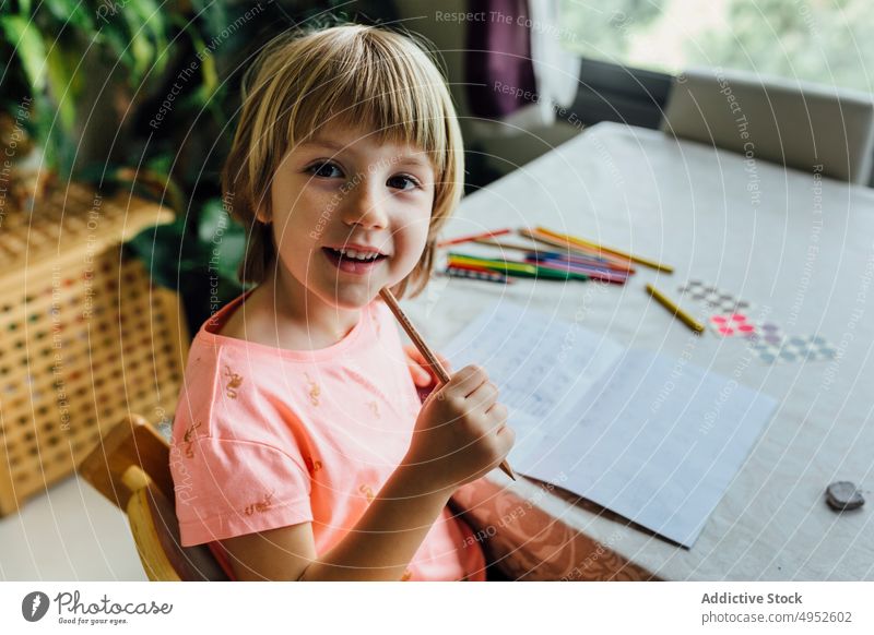 Cute Little Girl Doing Homework child girl portrait cheerful playful homework smiling education looking at camera indoors happy writing sit alone attention