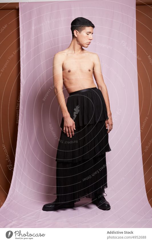 Feminine gay with naked torso on pink background model homosexual man feminine accept identity gentle touch thigh portrait skirt belt garment style lgbt