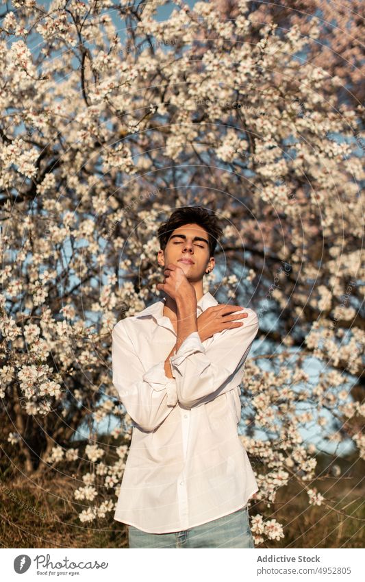Young Man Near Blooming Tree In Garden tree flower nature park season branch outdoors garden flora almond aroma bloom blossom blur botany calm environment
