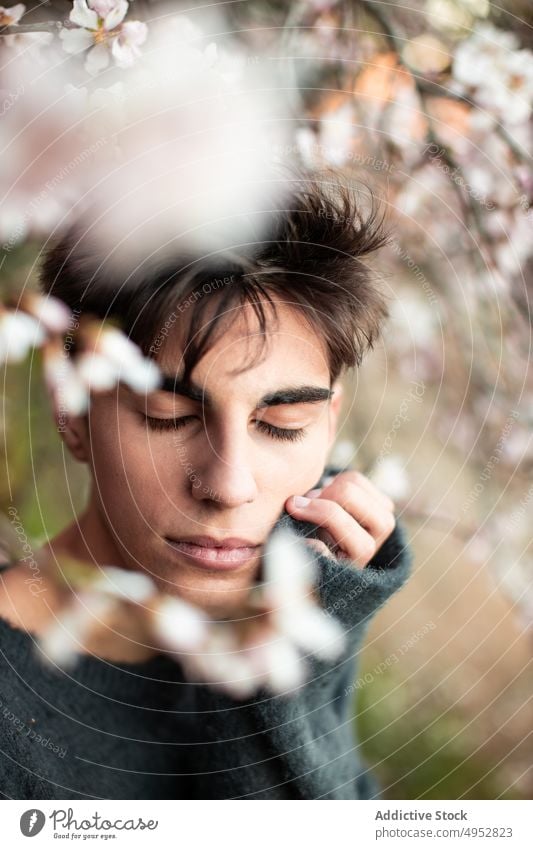 Young Man wit closed eyes Under Blooming Tree nature flower tree outdoors model park almond bloom blossom blur botany branch calm elegant environment flora