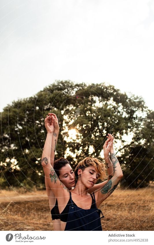 Sensual lesbians hugging in countryside couple sensual closed eyes love women homosexual together joy carefree summer underwear nature cloudy sky overcast