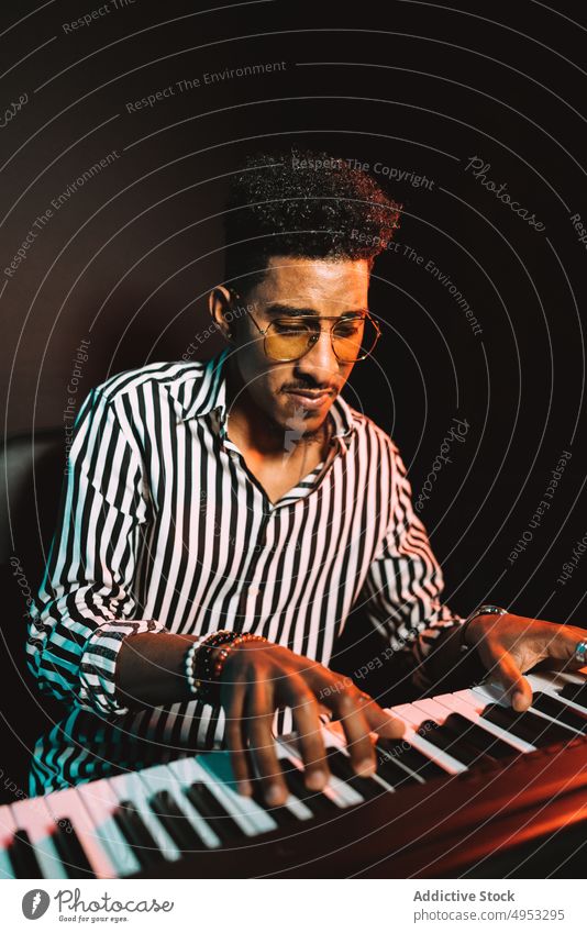 Black man playing synthesizer in studio musician audio hobby record skill acoustic male piano electric perform sound melody player tune instrument rehearsal