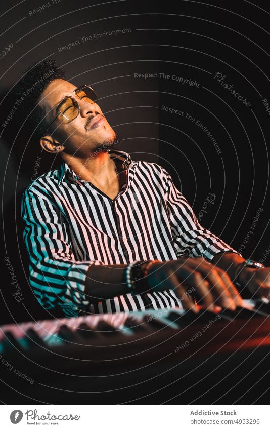 Black man playing synthesizer in studio musician audio hobby record skill acoustic male piano electric perform sound melody player tune instrument rehearsal