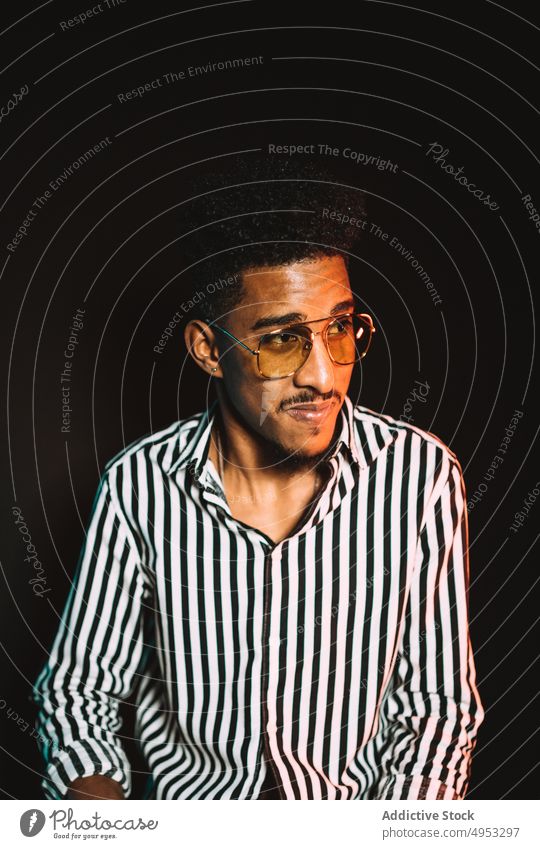Portrait of confident black man with eyeglasses style masculine macho cool brutal put on jacket dandy male sunglasses well dressed unshaven adjust young