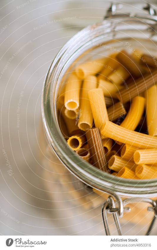 Jar full of macaroni pasta uncooked raw food italian cuisine jar glass container ingredient dry yellow healthy traditional cooking meal nutrition wheat dinner