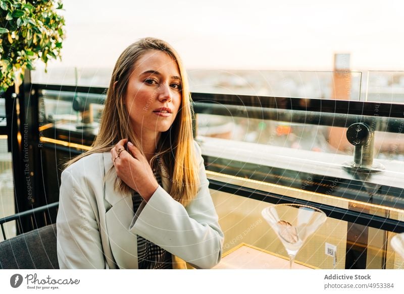 Woman sitting at table in rooftop cafe woman evening enjoy restaurant style chill female relax city elegant calm lean on hand lady young trendy summer serene