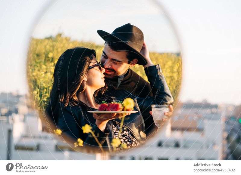 Ethnic couple with strawberries reflecting in mirror in town boyfriend girlfriend reflection relationship love strawberry dreamy city meadow spend time romantic