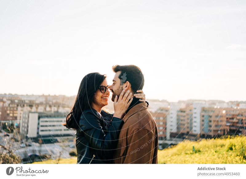 Smiling ethnic couple embracing against urban buildings embrace love relationship cheerful talk spend time soulmate city sky smile content speak glad candid