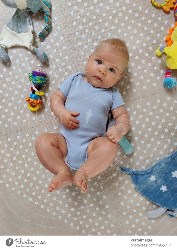 Curious beautiful baby boy in blue body lying on playing mat, looking in the camera Boy (child) Baby adorable newborn Newborn kid Infancy Child cutie cute