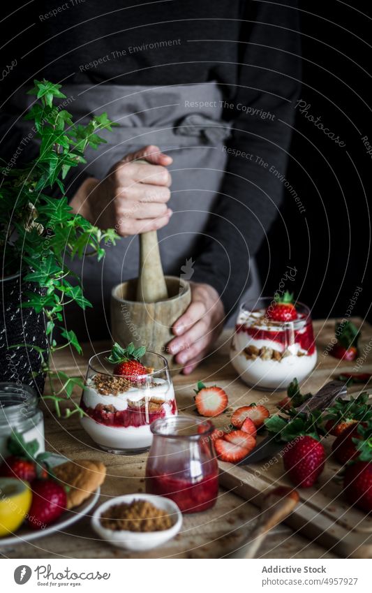 Chef cooking tasty dessert with fresh berries in dark kitchen strawberry mortar cheese food hand cuisine vitamin sweet person healthy slice gastronomy dairy
