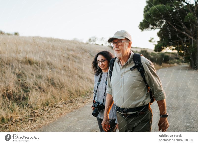Happy senior couple standing in peaceful countryside happy carefree field embrace meadow mature photographer cheerful friend nature hike photography together