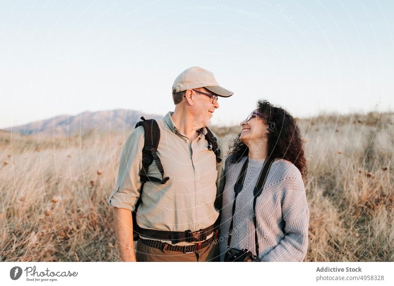 Happy senior couple standing in peaceful countryside happy carefree field embrace meadow mature cheerful friend nature hike casual together wife husband content
