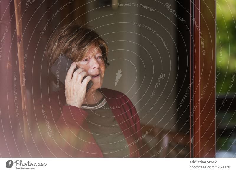 Senior woman making call at home speak smartphone retire wrinkle rest connection listen female elderly mature mobile senior conversation aged device gadget cozy