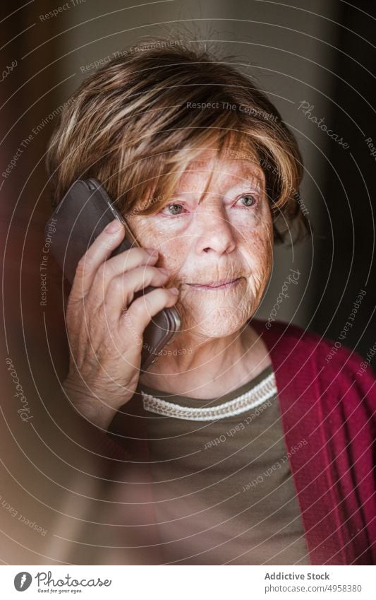 Senior woman making call at home speak smartphone retire wrinkle rest connection listen female elderly mature mobile senior conversation aged device gadget cozy