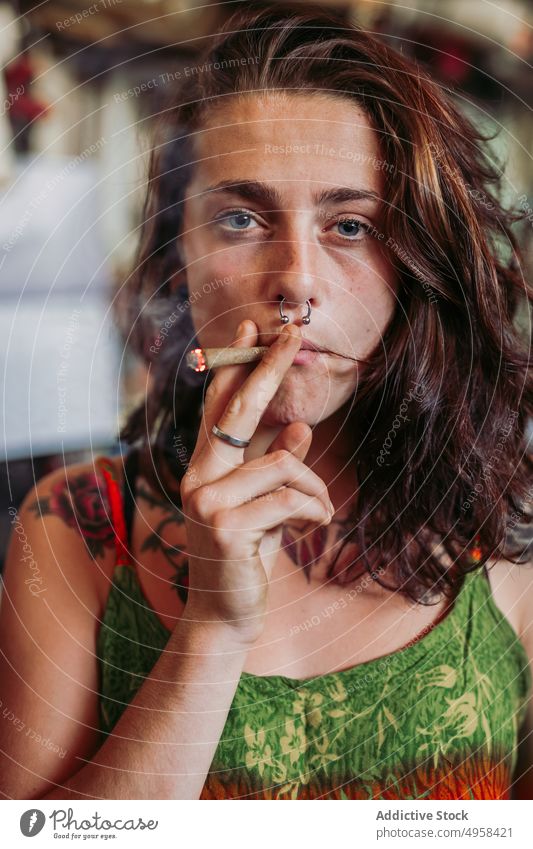 Woman smoking joint at home using weed blunt woman casual young female addiction cigarette freedom hipster relax resting lounge pastime standing creative