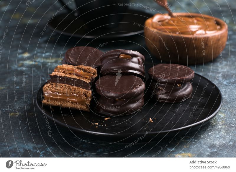 Chocolate alfajores and dulce de leche near hot chocolate dessert sweet delicious tasty plate food yummy appetizing portion confectionery cut glaze fill