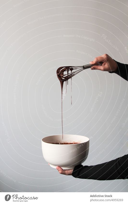 Crop hands draining chocolate from a whisk sweet delicious food dessert cream drop cooking liquid mix brown candy gourmet dirty pour shake melted beater droplet