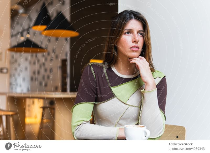 Contemplative woman with cup of coffee in cafe hot drink beverage thoughtful contemplative charming aroma cafeteria portrait contemplate feminine gentle