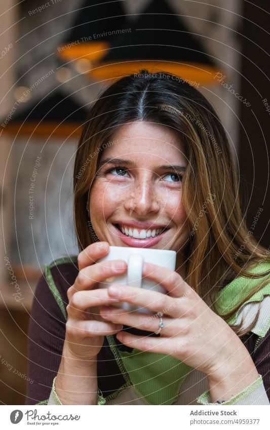 Contemplative cheerful woman with cup of coffee in cafe hot drink beverage contemplative charming happy aroma cafeteria portrait contemplate toothy smile