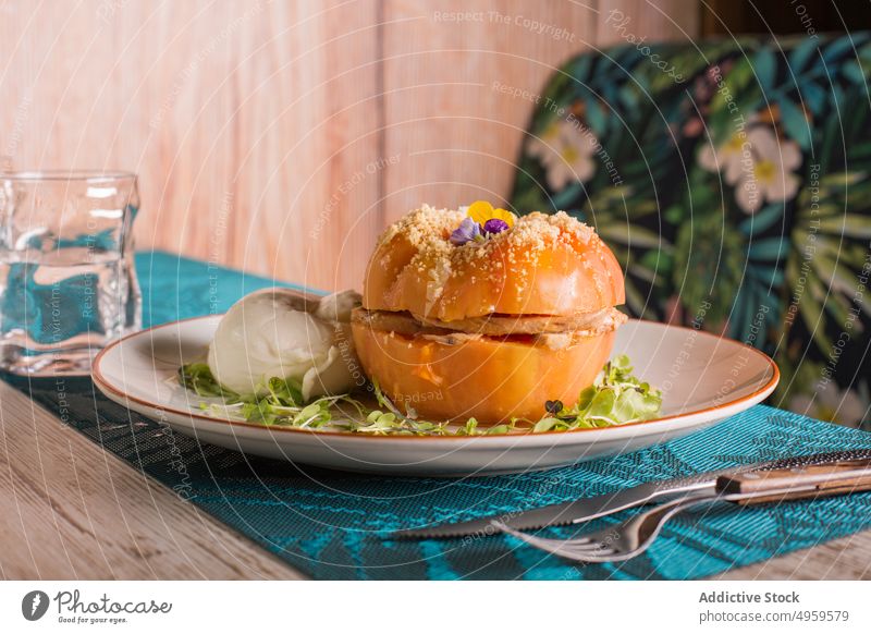 Stuffed tomato on plate in cafe stuff dish serve vegetable appetizing food restaurant meal delicious tasty pink wooden green herb garnish nutrition cuisine