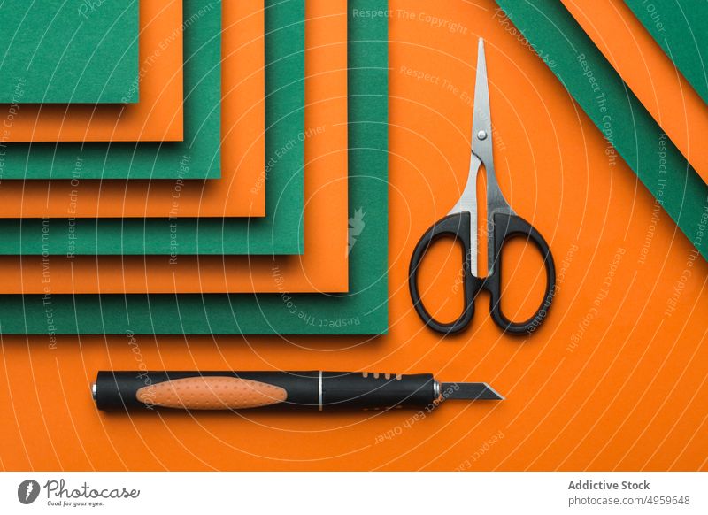 Scissors and cutter on green and orange cardboard background clean clipping color colorful concept craft design geometric object paper patter scissors shadow