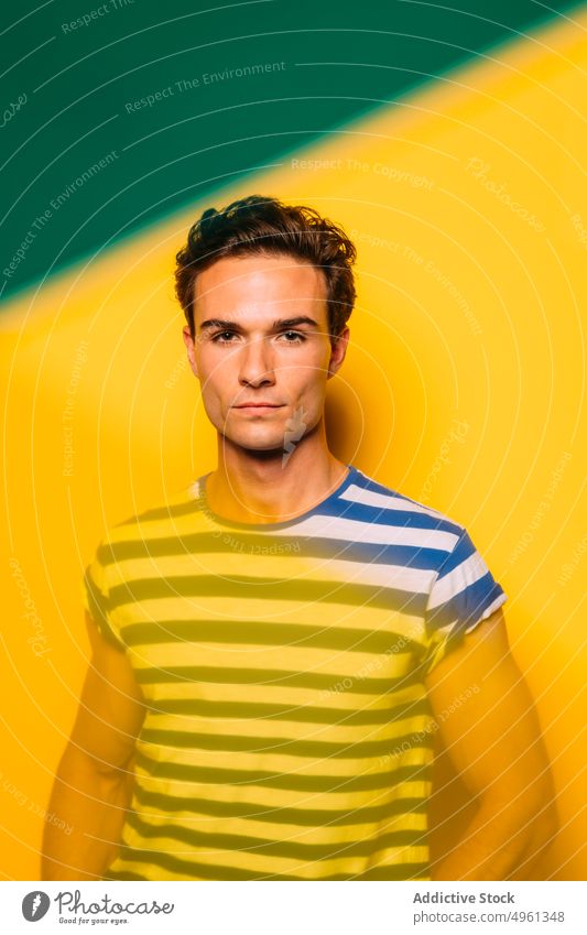 Stylish model with modern haircut on colorful background fashion style individuality muscular confident man bright portrait trendy stripe stylish wear