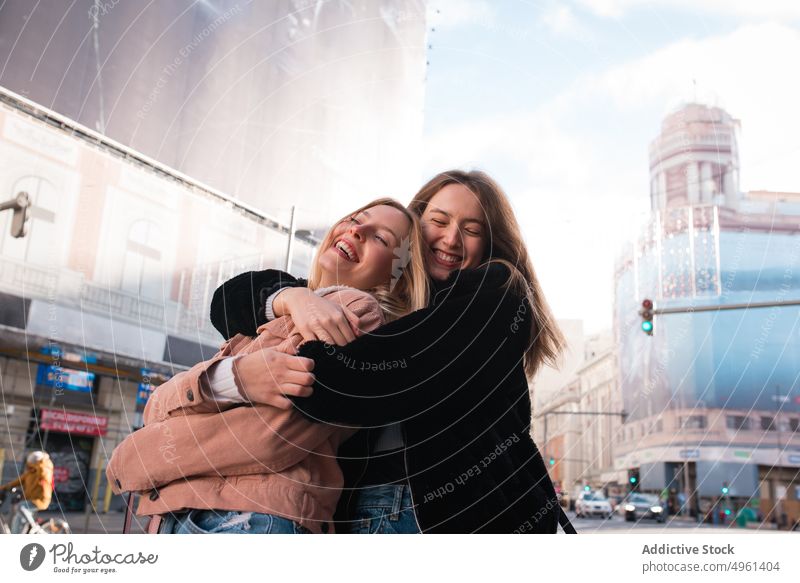 Happy women hugging on street during city stroll friend friendship best friend embrace cheerful having fun enjoy female madrid spain spend time together weekend