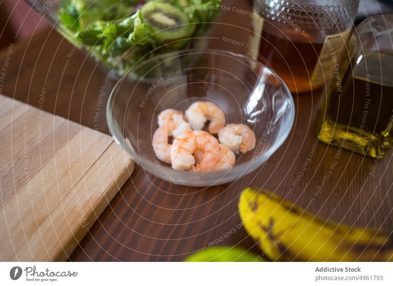 Shrimps in glass bowl on table shrimp ingredient cook kitchen food cuisine culinary fresh dish recipe seafood gourmet oil salad chopping board natural
