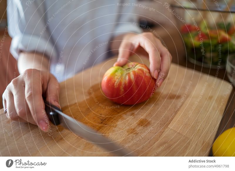 Crop woman cutting tomato for salad cutting board cook fresh home kitchen lunch female knife prepare slice chopping board vegetable healthy food vitamin