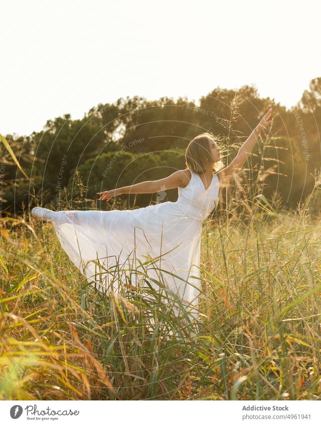 Woman dancing in field at sunrise woman dance summer countryside nature grass bend arabesque motion grace female white dress sunlight sunset meadow morning