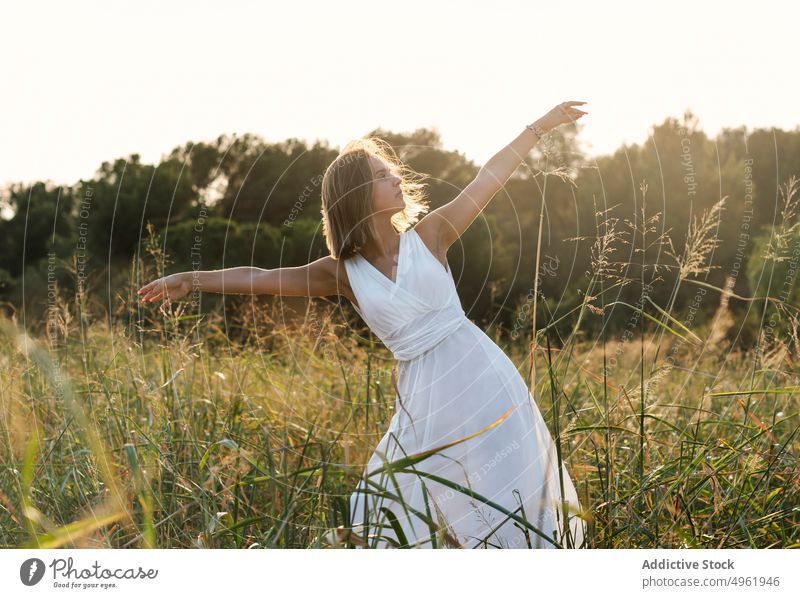 Woman dancing in field at sunrise woman dance summer countryside nature grass bend grace female white dress sunlight sunset meadow morning outstretch arms