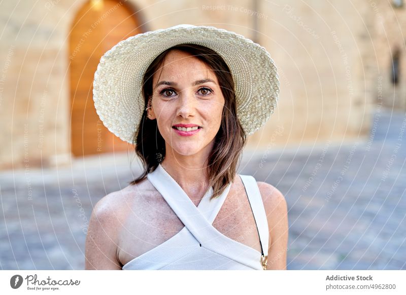 Traveling woman in hat in old town tourist portrait smile travel summer appearance female city vacation sunhat street traveler content top summertime stone