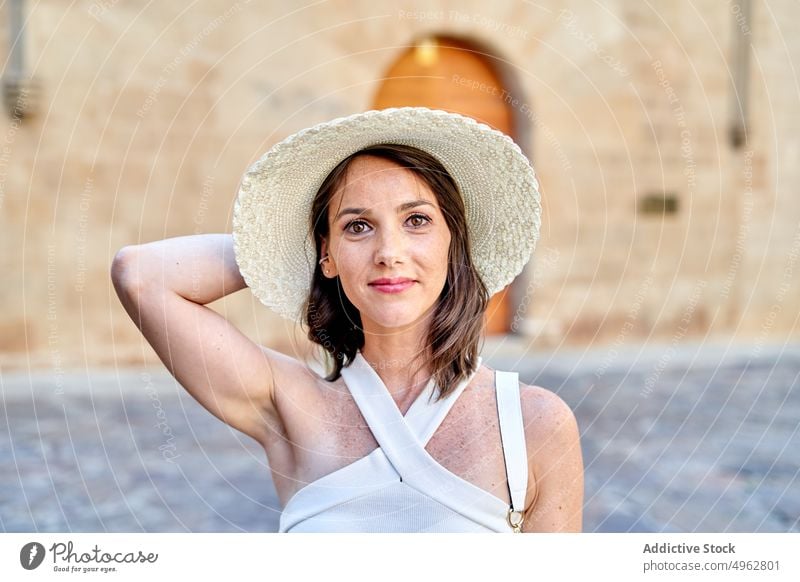Traveling woman in hat in old town tourist portrait smile travel summer appearance female city vacation sunhat street traveler content top summertime stone