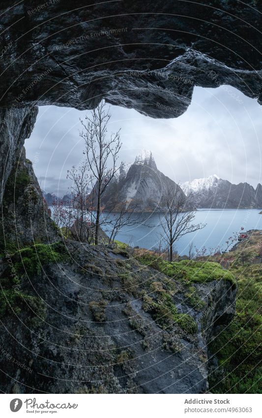 Scenic landscape of picturesque fjord against cloudy sky in Norway mountain cave hole sea cliff highland overcast nature ridge range environment rocky scenic