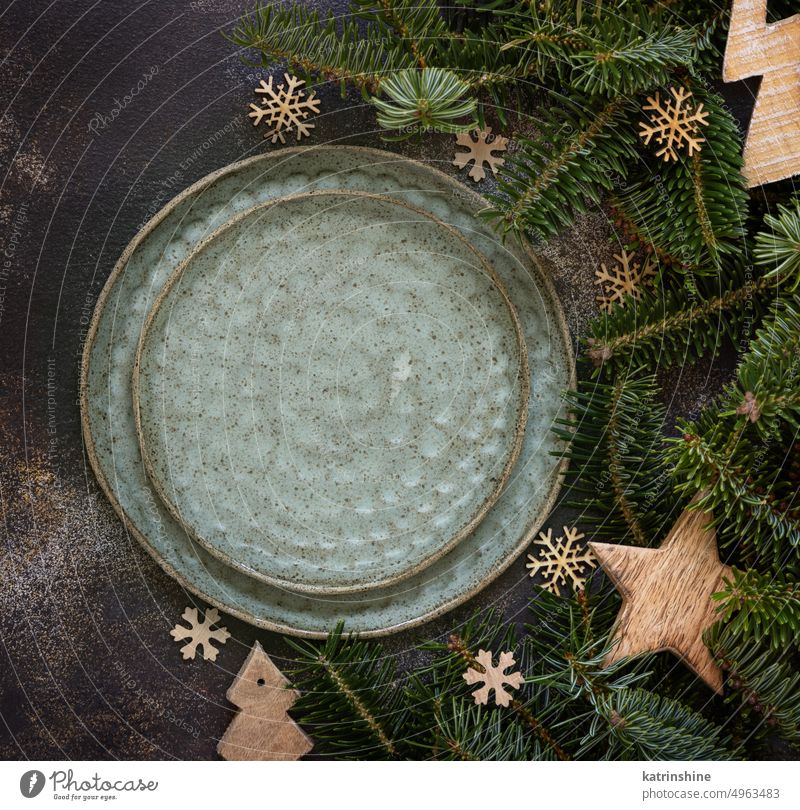 Festive table setting with fir tree branches and Rustic Christmas decorations on dark table top view christmas table place ornaments rustic plates holiday