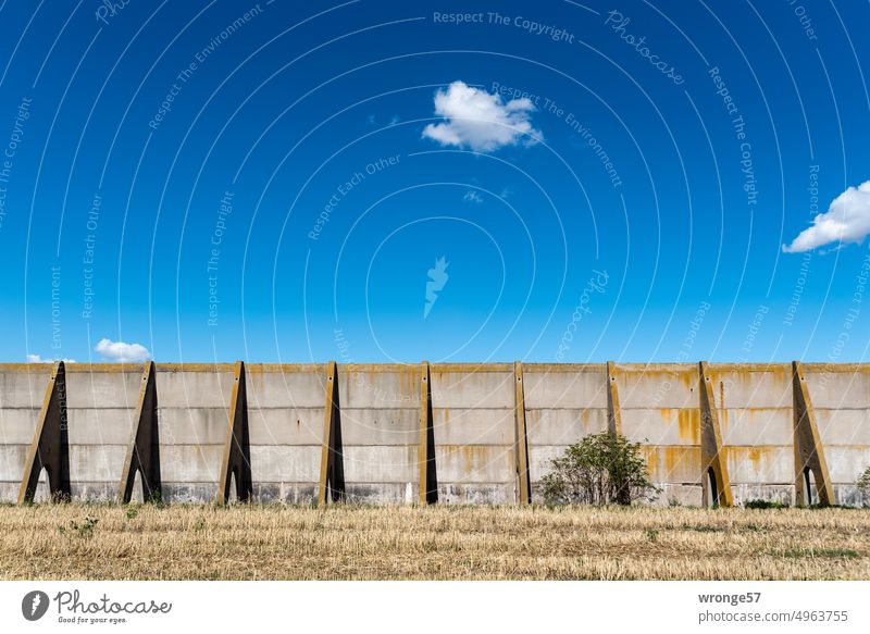 Outside wall of silo on the field under blue sky exterior wall Silo Driving silo Concrete elements Blue sky small clouds little cloud Beautiful weather