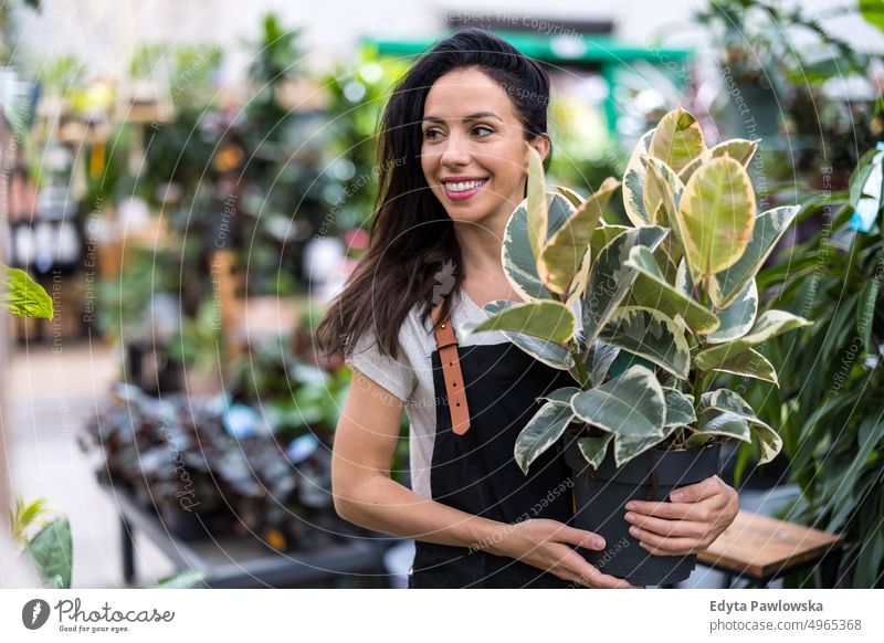 Shot of a young woman working with plants in a garden centre plant nursery smiling positivity nature gardening cultivate growth hobby freshness growing flora