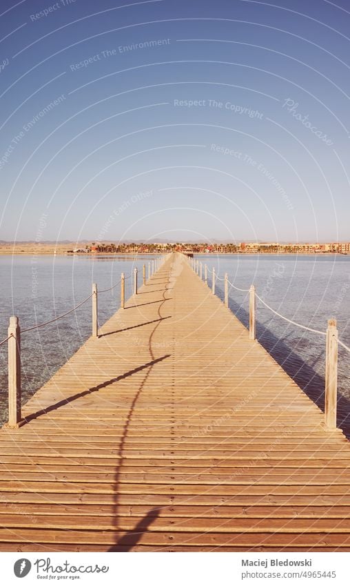 Wooden pier at sunrise, color toning applied. travel sea ocean water nature retro tropical tranquil sky vacation wood horizon sunset jetty blue destination