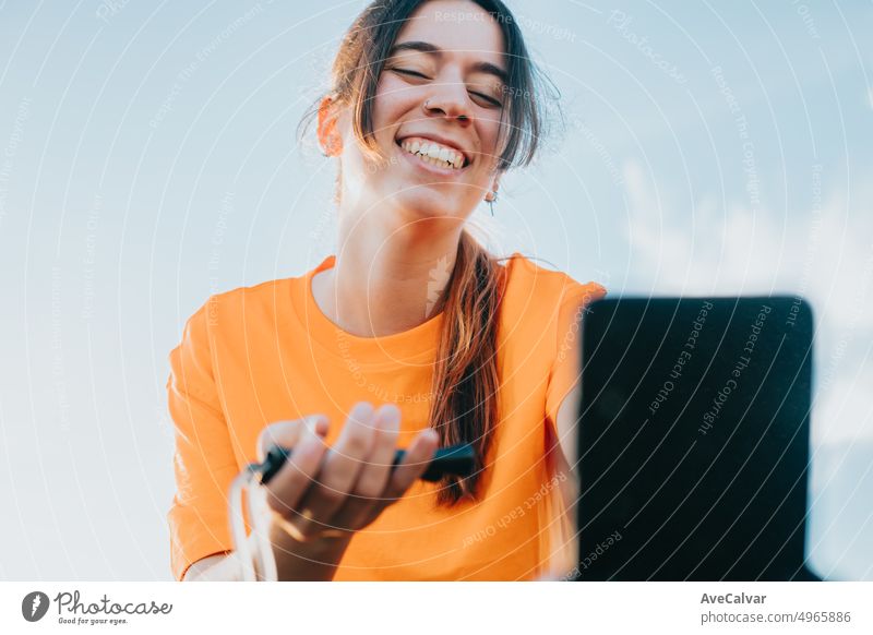 Young woman holding a jumping comb and showing it to followers on stream live, healthy influencer. Sport and healthy life style on social network content. Urban place, workout in the city