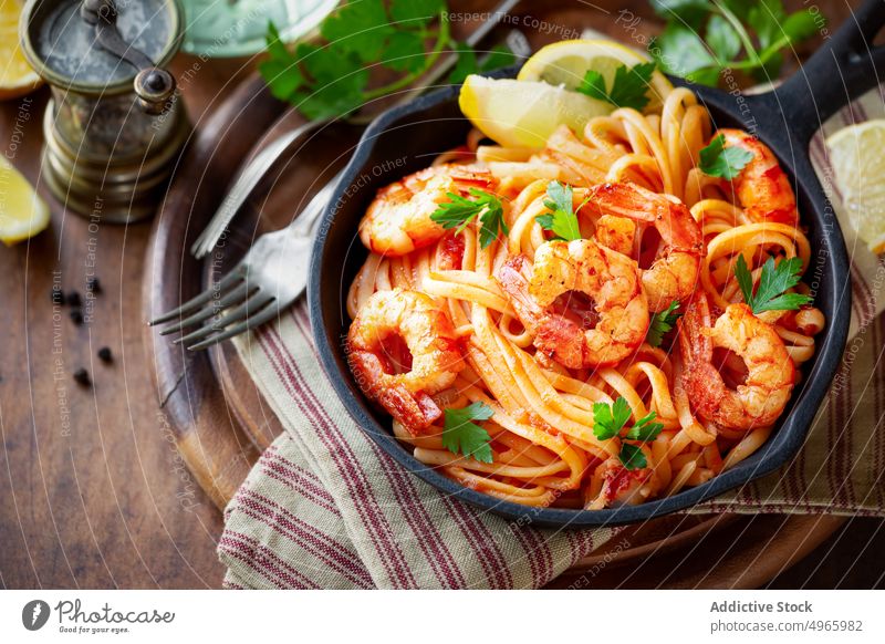 Pasta with shrimps on table prawn spaghetti pasta italian tomato seafood shellfish cuisine sauce parsley napkin cloth lemon rustic tradition recipe cooked