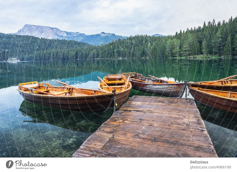 Black lake with boats on mount Durmitor, Montenegro black lake montenegro durmitor mountain visit calm mountains water jetty no people nobody several object
