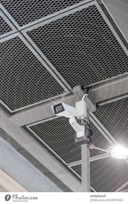 A video surveillance camera under a metal ceiling alarm cctv cctv security concept control copy space crime danger device digital electronic equipment facility