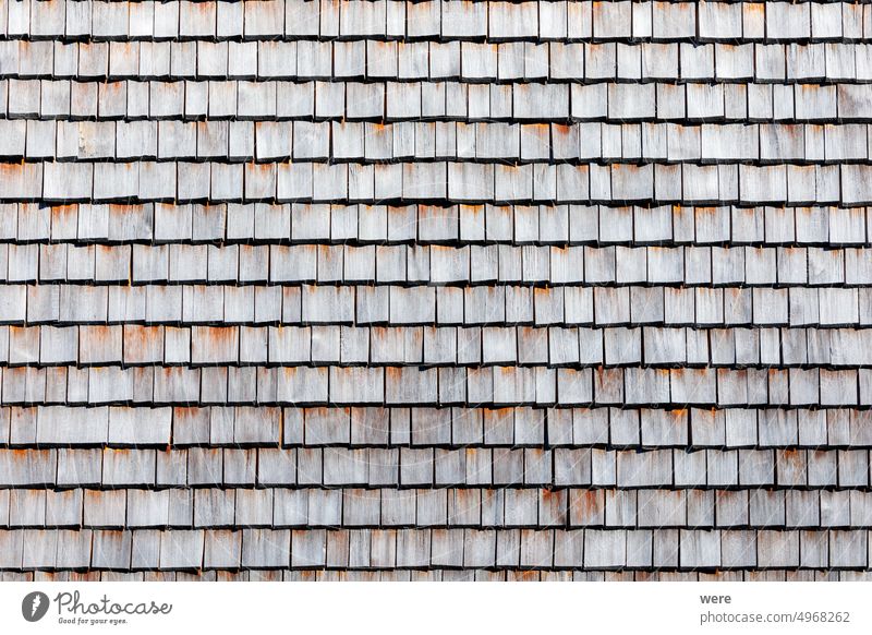 Traditional house wall cladding from weathered cut rectangular wooden shingles Background Pattern building copy space historic nobody old residential building