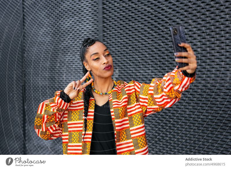 Stylish woman taking selfie on street smartphone style v sign pouting lips wall urban gesture female young ethnic modern two fingers trendy street style