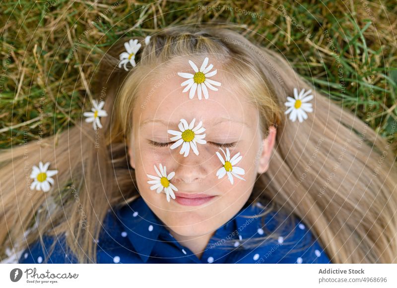 Girl with daisies on face girl flower daisy smile grass field countryside blond happy eyes closed portrait weekend blossom bloom fresh kid meadow nature child