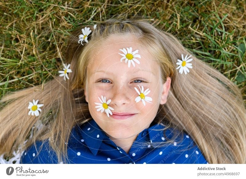 Girl with daisies on face girl flower daisy smile grass field countryside blond happy portrait weekend blossom bloom fresh kid meadow nature child lying flora
