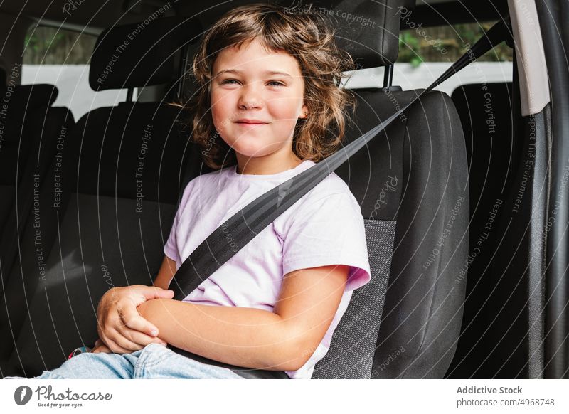 Cheerful girl sitting in car smile backseat road trip happy weekend travel female passenger casual kid journey positive transport auto vehicle ride child